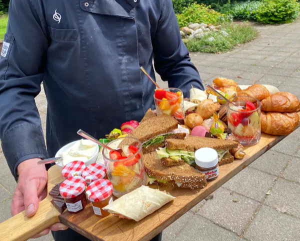 Een brunchplank met broodjes, croissants en fruit