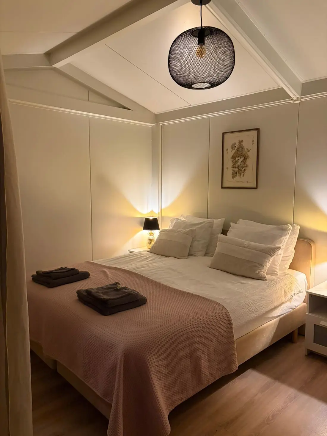 De tuinkamer met warm licht en een opgemaakt bed